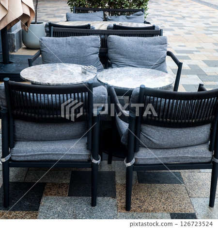 Charming Outdoor Caf Table with Gray Chairs Inviting Atmosphere for Relaxation and Dining 126723524