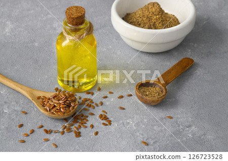 Flax seeds. Flaxseed powder in a wooden spoon. Standing on a Wooden background. 126723528