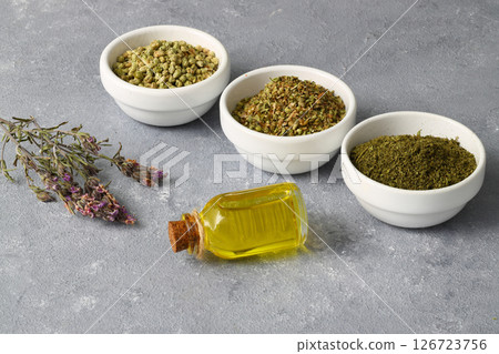 thyme(Oregano) essential oil and Heap of dry thyme in wooden spoon and in bowl on wooden background 126723756