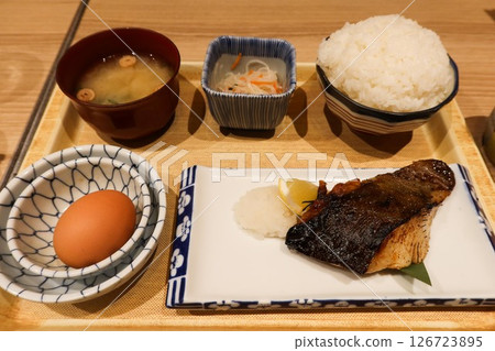 close up of Japanese breakfast morning set of an raw egg, a bowl of rice, miso soup and grilled marinated black cod fish ( Gindara Saikyo Yaki) in a set close up of Japanese breakfast morning set of an raw egg, a bowl of rice, miso soup and grilled marinated black cod fish ( Gindara Saikyo Yaki) in a set 126723895