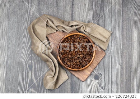 Wooden bowl with coffee beans on wooden background 126724325