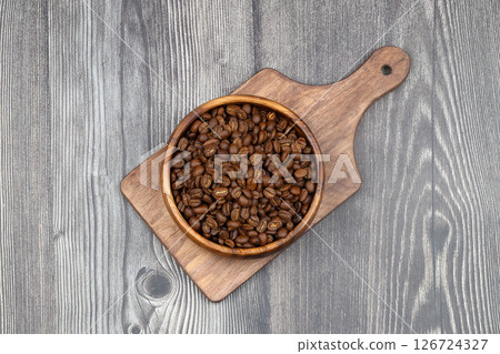 Wooden bowl with coffee beans on wooden background 126724327