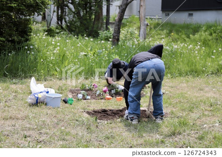 Back view of an elderly couple gardening in their home garden Back view of an elderly couple gardening in their home garden 126724343