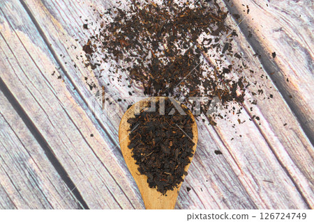 Dry black tea leaves isolated on wooden background, top view 126724749