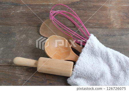 Set of utensils in towel on wooden. Set of utensils in towel on wooden. 126726075