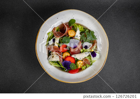 Salad mix with jamon, baby mozzarella, strawberries and vinaigrette sauce. 126726201