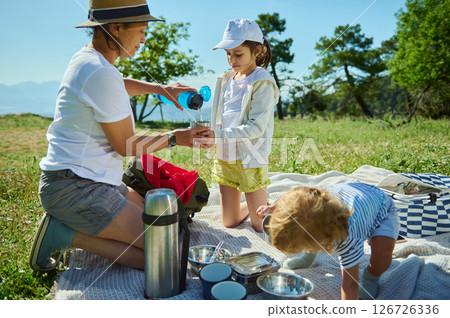 Family Enjoying a Summer Mountain Picnic Outdoors with Scenic Views 126726336