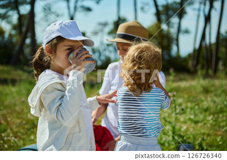 Mother and Children Sharing Fun Moments During a Summer Picnic in Nature Mother and Children Sharing Fun Moments During a Summer Picnic in Nature 126726340