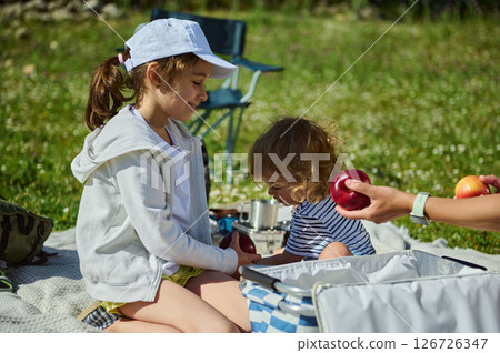 Family Enjoying a Sunny Picnic Amid Stunning Mountain Summer Landscape Family Enjoying a Sunny Picnic Amid Stunning Mountain Summer Landscape 126726347