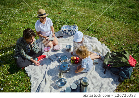 Family Enjoying a Sunny Picnic Day Together Outdoors in Summer Nature Family Enjoying a Sunny Picnic Day Together Outdoors in Summer Nature 126726358