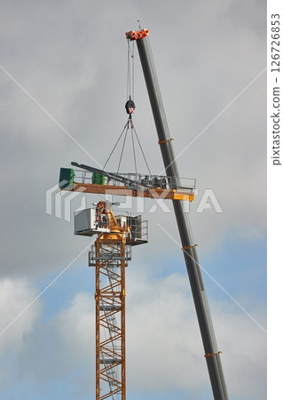 Tall Construction Cranes being assembled 126726853