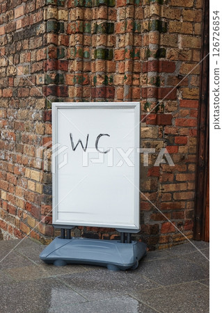 WC sign board at old brick building entrance 126726854