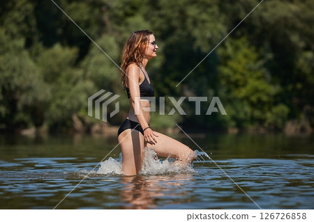 Girl at the beach running into the water Girl at the beach running into the water 126726858