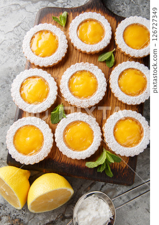 Cookies combine two layers of buttery Shortbread Cookies and a homemade tangy Lemon Curd filling closeup on wooden board. Vertical top view 126727349