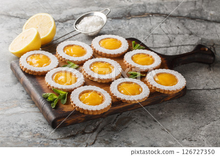 Homemade lemon curd shortbread cookies in the shape of a flower sprinkled with powdered sugar closeup on wooden board. Horizontal Homemade lemon curd shortbread cookies in the shape of a flower sprinkled with powdered sugar closeup on wooden board. Horizontal 126727350