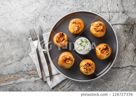 Baked Knysh pies with onion potato filling served with sour cream close-up in a plate. Horizontal top view Baked Knysh pies with onion potato filling served with sour cream close-up in a plate. Horizontal top view 126727356