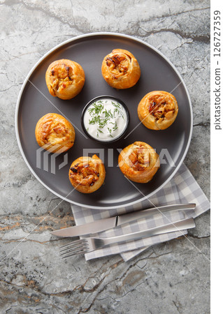 Knish or knysh is a traditional food of Eastern European consists of a filling covered with dough that is baked closeup on the plate. Vertical top view 126727359