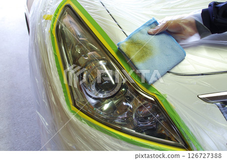 A microfiber cloth used to clean the surface of a headlight that had become discolored due to aging has turned ochre-colored. A microfiber cloth used to clean the surface of a headlight that had become discolored due to aging has turned ochre-colored. 126727388