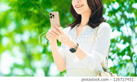 Woman/businesswoman using smartphone outdoors in summer 126727451