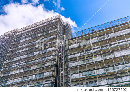 Yokohama cityscape in Japan. Apartment building repairs and inspections, scaffolding and protective nets. Satellite antennas outside the nets... 126727502