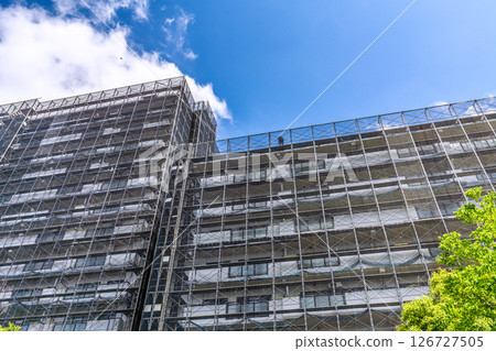 Yokohama cityscape in Japan. Apartment building repairs and inspections, scaffolding and protective nets. Satellite antennas outside the nets... 126727505