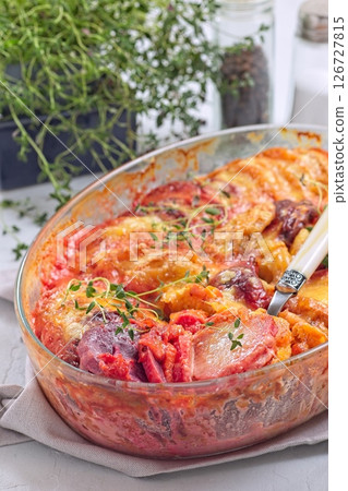 Sweet potato, parsnips and beet root au gratin with thyme and melted cheese, in glass dish, vertical Sweet potato, parsnips and beet root au gratin with thyme and melted cheese, in glass dish, vertical 126727815