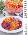 Sweet potato, parsnips and beet root au gratin with thyme and melted cheese, on plate, vertical 126727836