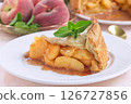 Delicious peach pie slice garnished with fresh mint, on white plate, horizontal 126727856