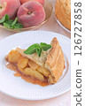 Old fashioned deep dish peach pie slice garnished with fresh mint, on white plate, vertical 126727858
