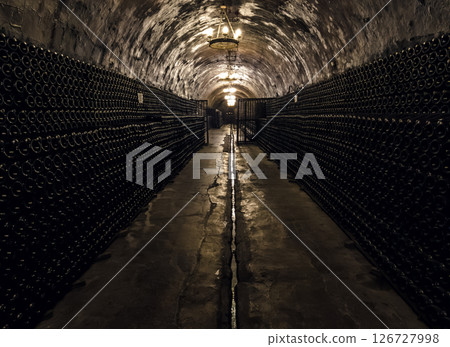 Dimly lit wine cellar with rows of bottles and warm lighting at dusk Dimly lit wine cellar with rows of bottles and warm lighting at dusk 126727998