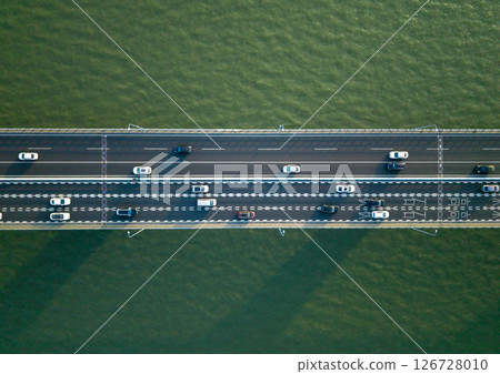 Top down view of highway traffic flows in both directions on a wide bridge spanning a river. Hangzhou, China. Top down view of highway traffic flows in both directions on a wide bridge spanning a river. Hangzhou, China. 126728010