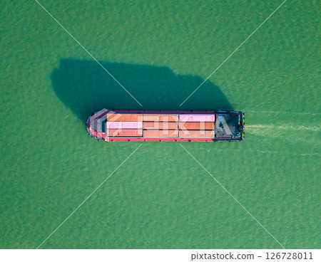 Aerial top down view of container ship navigates calm ocean waters near coastal region during bright daylight. Hangzhou, China. Aerial top down view of container ship navigates calm ocean waters near coastal region during bright daylight. Hangzhou, China. 126728011