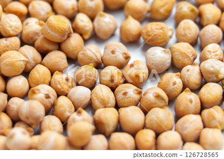 Raw chickpea grains on kitchen ceramic plate. Dry uncooked protein fiber ingredient 126728565