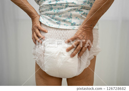 Asian senior woman patient wearing adult incontinence diaper pad in hospital. 126728682