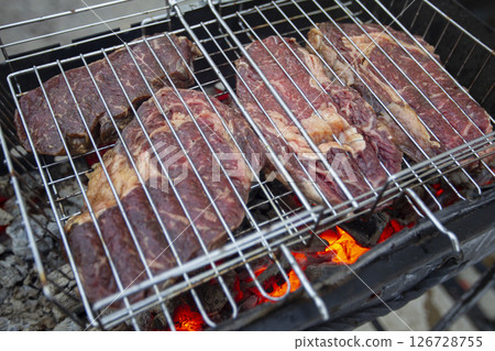 Large cuts of beef meat on the grill rack. Grilled barbecue meat. Large cuts of beef meat on the grill rack. Grilled barbecue meat. 126728755