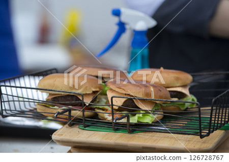 Cooking hamburgers on the wire rack. Street food. Cooking hamburgers on the wire rack. Street food. 126728767