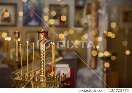 Candles on the background of the church interior and golden bokeh. 126728773