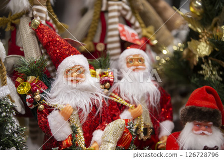 Toy santa claus on the background of the christmas tree. Festive Christmas background. Toy santa claus on the background of the christmas tree. Festive Christmas background. 126728796