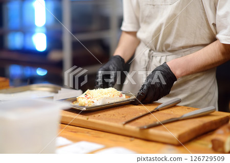 Close-up view of a restaurant or cafe kitchen and workers preparing food for customers. 126729509