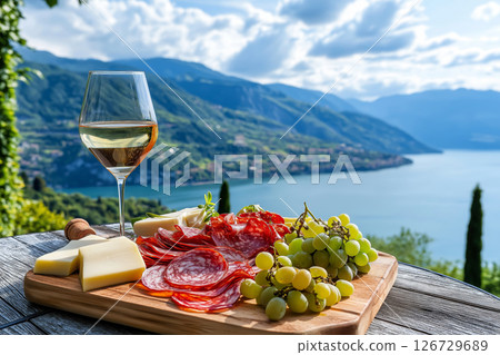 lake view picnic with wine, cheese, grapes, and salami lake view picnic with wine, cheese, grapes, and salami 126729689