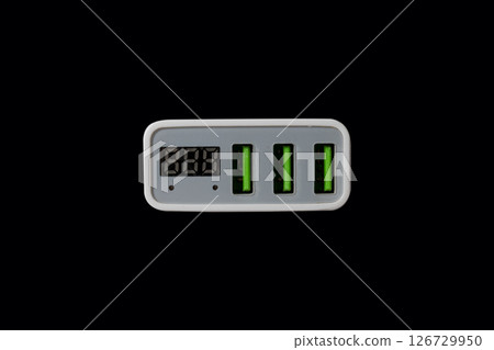 USB adapter for charging multiple mobile phones and modern devices on a black background 126729950