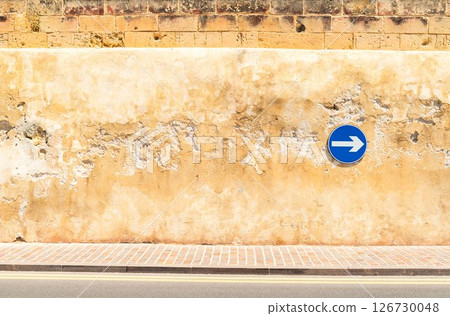 Cracked wall with a safety sign on it, proceed right only Cracked wall with a safety sign on it, proceed right only 126730048