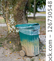 Trash bin with dirt in natural outdoor setting beside tree, showing urban waste and environmental decay Trash bin with dirt in natural outdoor setting beside tree, showing urban waste and environmental decay 126730548