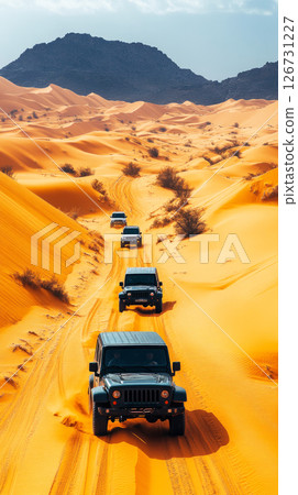 Convoy drives through deep dunes, sun blazing and sand swirling as off-road rigs push across wild heat in a raw test of power and grit 126731227
