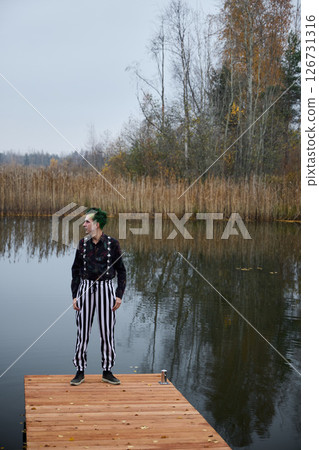 A Mysterious Character Standing upon a Dock Surrounded by Tranquil and Serene Waters A Mysterious Character Standing upon a Dock Surrounded by Tranquil and Serene Waters 126731316