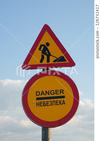 Danger and Road Work Warning Sign in Ukraine with Bilingual Text. Road safety, construction, danger zones, multilingual signs, and traveling in Ukraine. Danger and Road Work Warning Sign in Ukraine with Bilingual Text. Road safety, construction, danger zones, multilingual signs, and traveling in Ukraine. 126731417