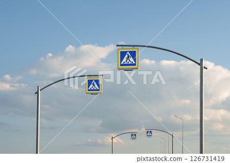 Modern Road with Pedestrian Crossing Signs under Blue Sky. Urban planning, traffic management, road safety, infrastructure and transport design. 126731419