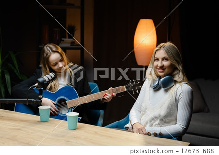 Musicians playing acoustic guitar and recording music in home studio 126731688