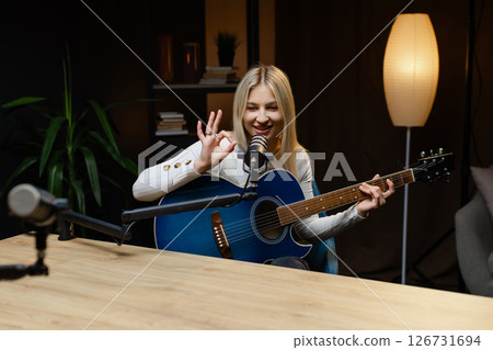 Musician playing guitar and singing during online lesson or concert Musician playing guitar and singing during online lesson or concert 126731694