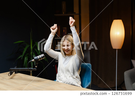 Excited female podcaster celebrating success in her home studio Excited female podcaster celebrating success in her home studio 126731699